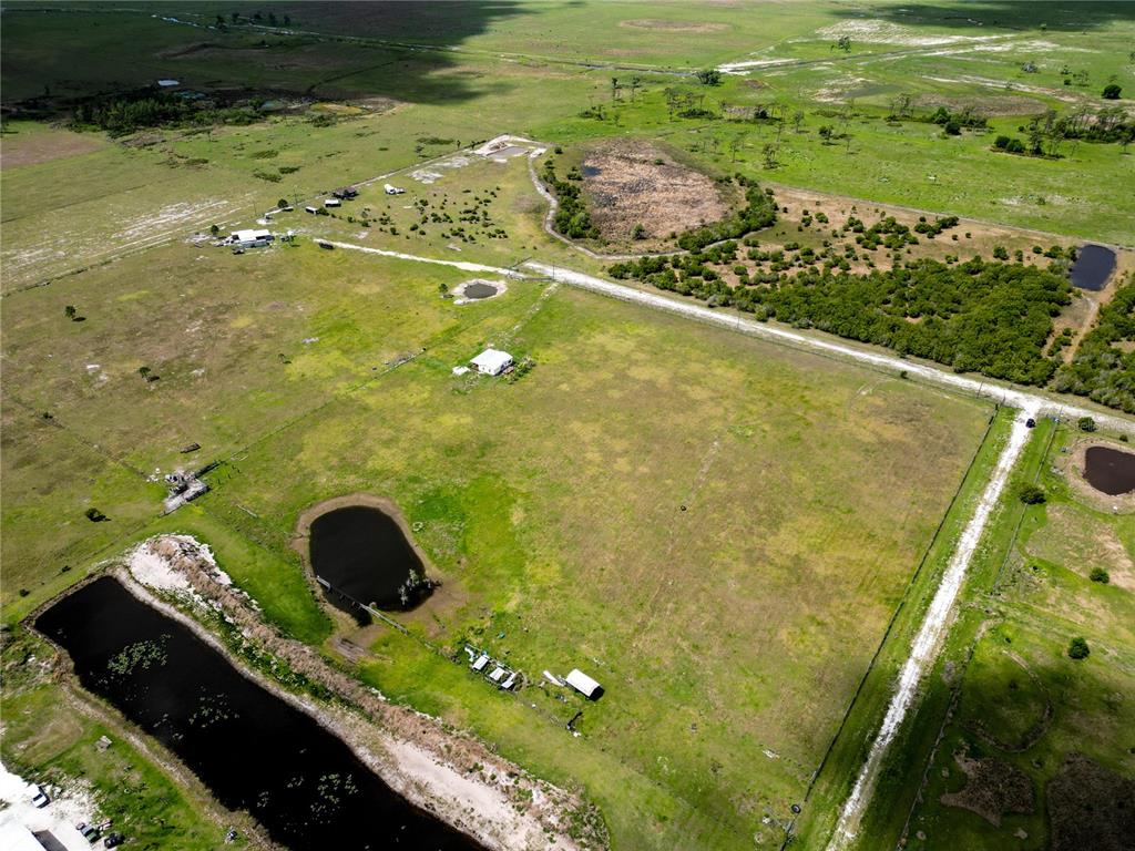 An aerial view shows a rural property with a house, several ponds, and open fields — 814 DACHSHUND ROAD, SEBRING, FL
