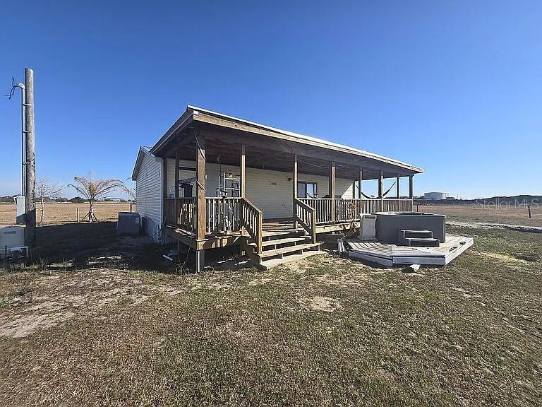 A single-story house features a large wooden porch and an outdoor hot tub — 814 DACHSHUND ROAD, SEBRING, FL