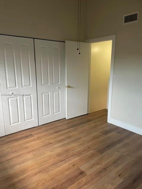 A room with light wood-look flooring, white paneled closet doors, and an open doorway — 8020 SW 152nd Ave # 306, Miami FL 33193, MIAMI, FL