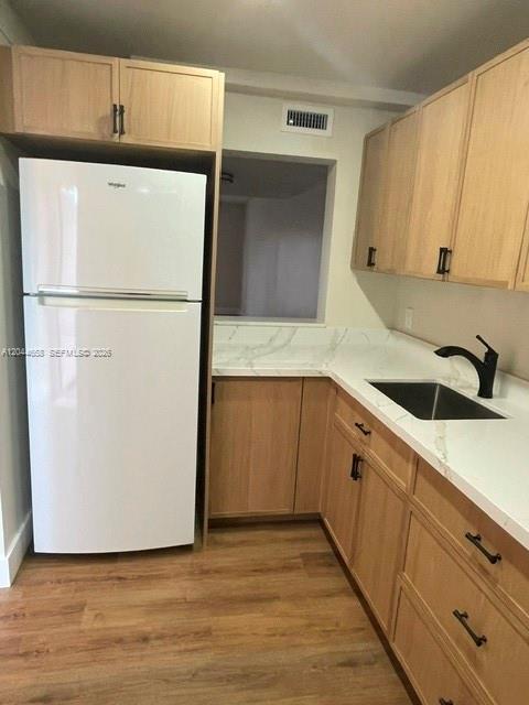 A kitchen features light wood cabinets, a white refrigerator, and a sink with a faucet — 8020 SW 152nd Ave # 306, Miami FL 33193, MIAMI, FL