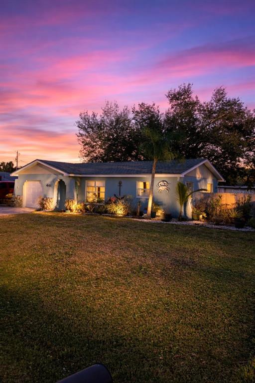 A single-story house with blue siding and a crab wall decoration at sunset — 441 CORONADO ROAD, VENICE, FL