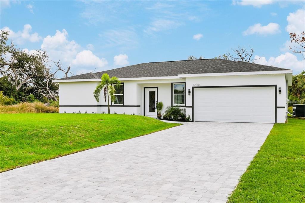 A single-story house with white stucco walls, a dark roof, and a paved driveway — 189 STATLER STREET, PORT CHARLOTTE, FL