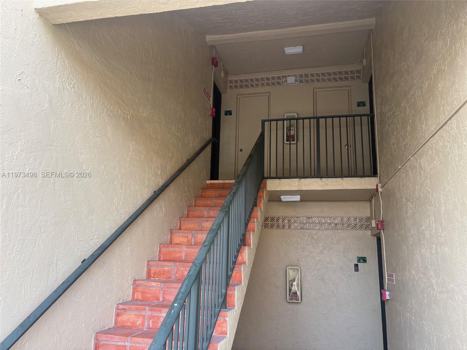 An outdoor staircase with terracotta steps leads to an upper landing with two apartment doors — 18304 NW 68th Ave # C, Hialeah FL 33015, HIALEAH, FL