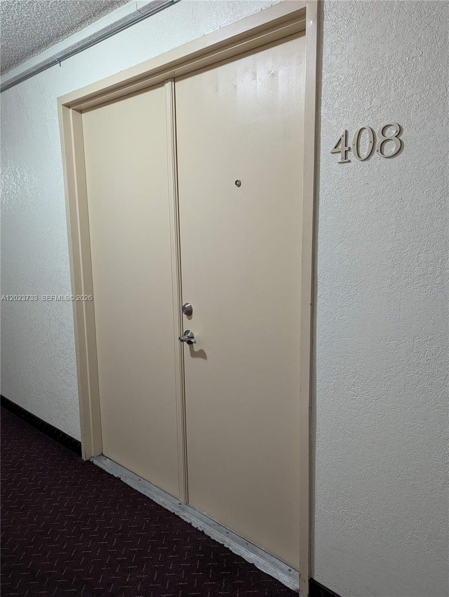 A beige double door with a peephole and handle is labeled with the number 408 — 16751 NE 9th Ave # 408, North Miami Beach FL 33162, NORTH MIAMI BEACH, FL