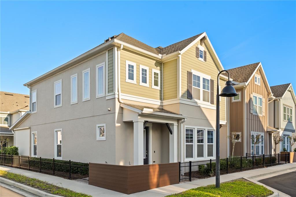 A two-story house with tan siding and a small brown privacy fence on a corner — 543 WISHBONE LANE, LAKE MARY, FL