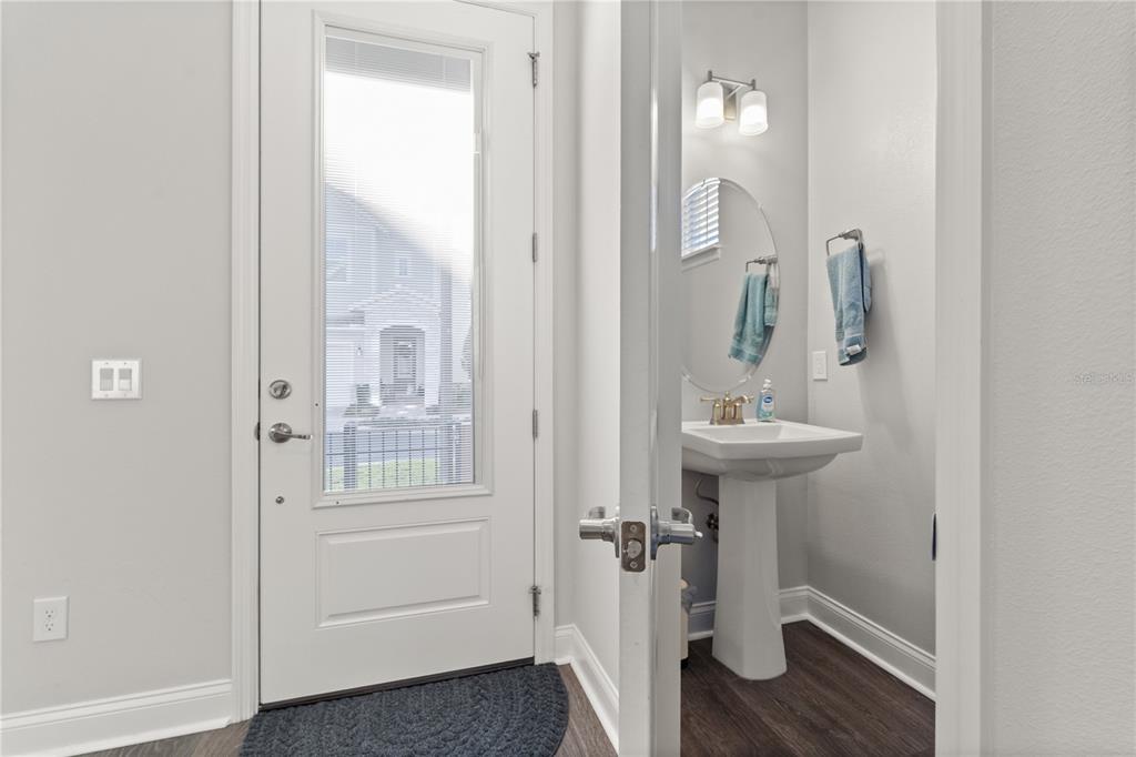 A white door with a glass pane opens to a small bathroom with a pedestal sink — 543 WISHBONE LANE, LAKE MARY, FL