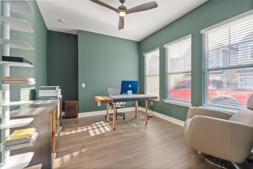 A home office with green walls, a desk, a swivel chair, and a white bookshelf — 543 WISHBONE LANE, LAKE MARY, FL
