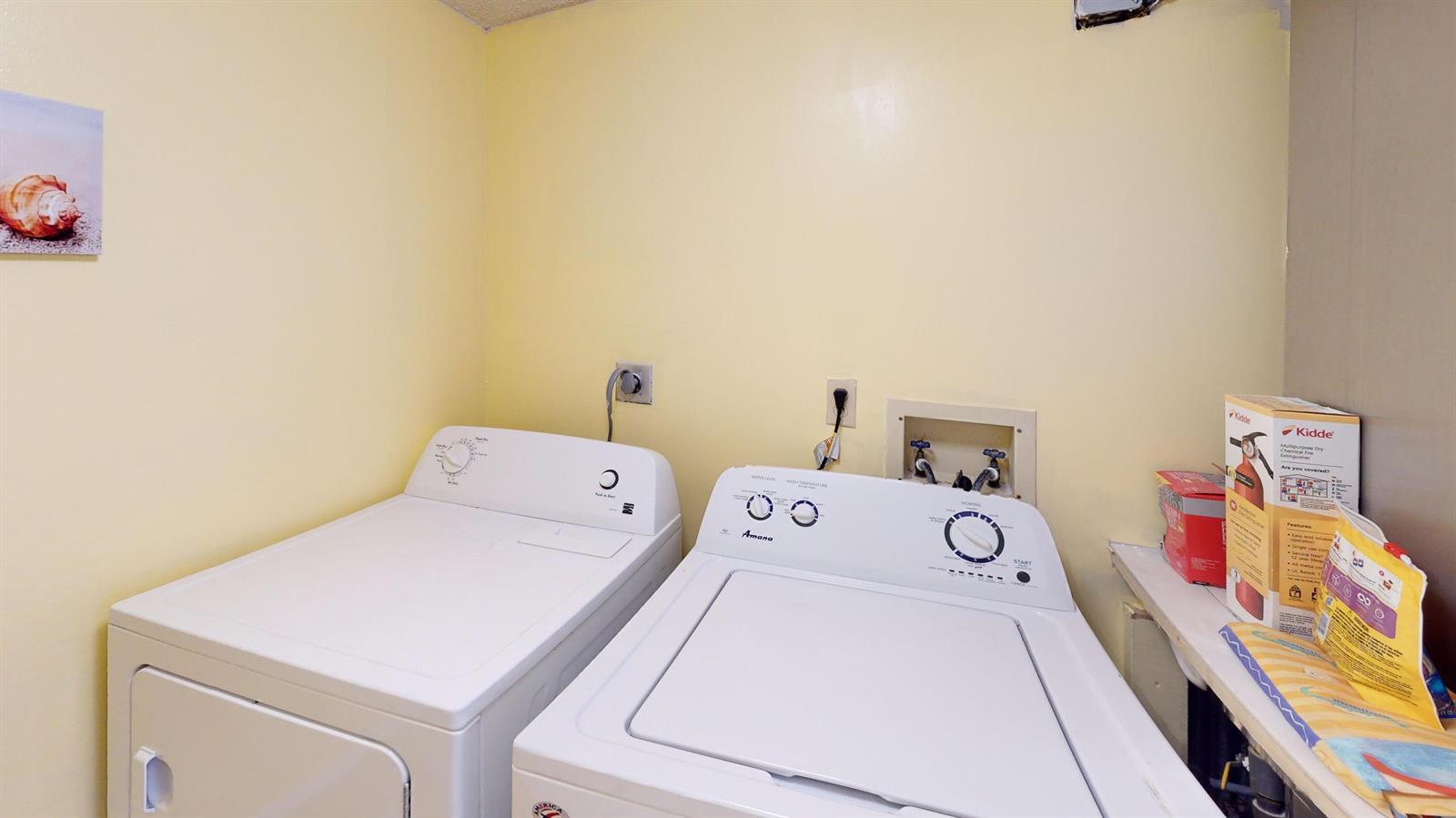 A laundry room features a white washer and dryer set against a yellow wall — 10044 S Ocean Drive # 805, Jensen Beach FL 34957, JENSEN BEACH, FL