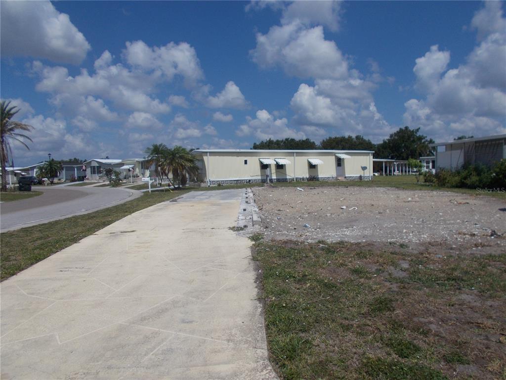 A vacant residential lot with a concrete driveway and a neighboring mobile home — 6581 CENTER LANE, NORTH PORT, FL