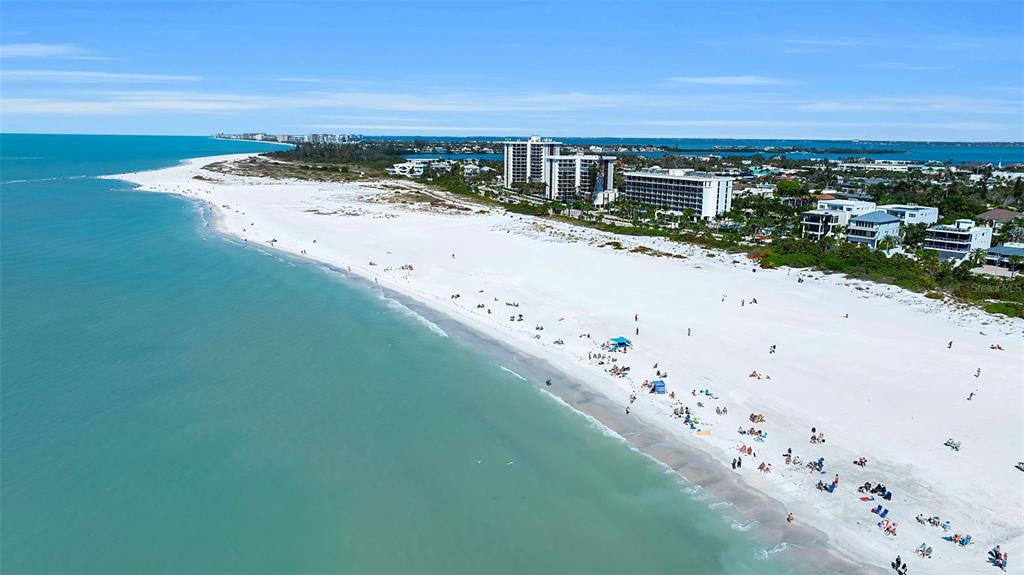 An aerial view of a white sand beach with turquoise water and nearby coastal buildings — 540 S POLK DRIVE, SARASOTA, FL