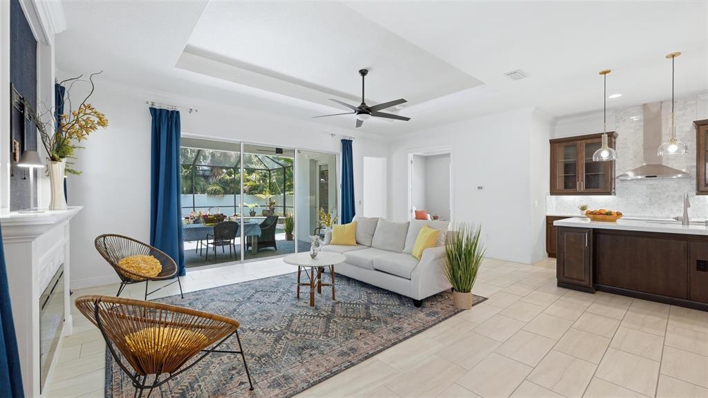 A living room features a fireplace, blue curtains, a patterned rug, and a ceiling fan — 1850 MAGNOLIA STREET, SARASOTA, FL