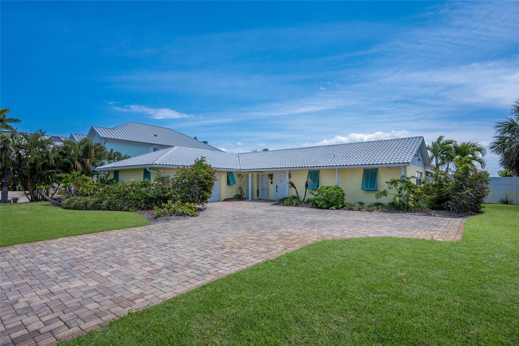 A single-story yellow house with a tiled roof and a paved driveway — 633 KEY ROYALE DRIVE, HOLMES BEACH, FL