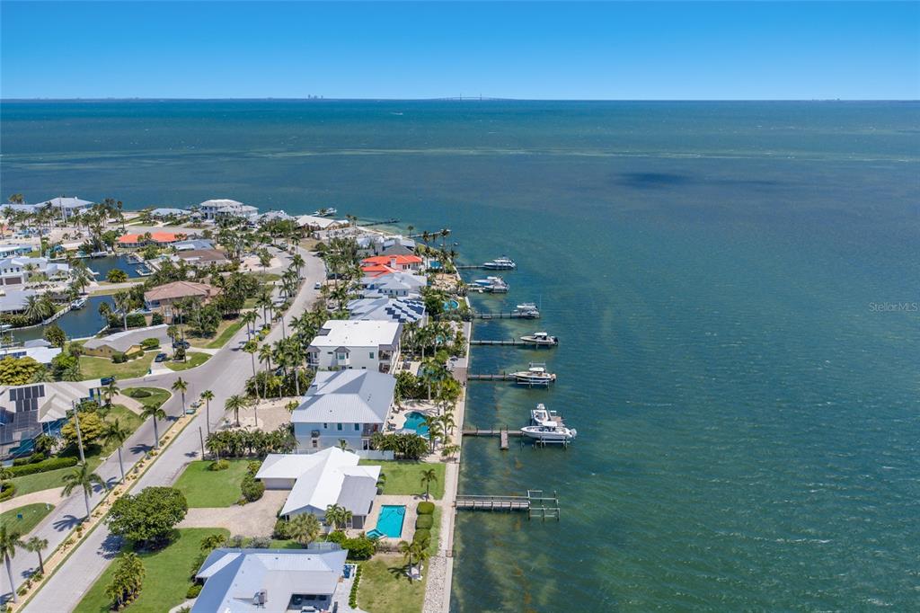 An aerial view shows waterfront homes with private docks along a coastal shoreline — 633 KEY ROYALE DRIVE, HOLMES BEACH, FL