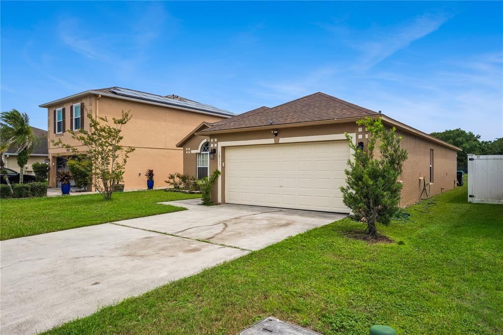 A single-story house with a beige stucco exterior and a two-car garage — 10337 LAXTON STREET, ORLANDO, FL