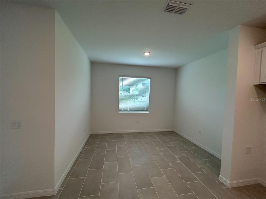 A modern kitchen features white cabinets, a gray hexagonal tile backsplash, and a stainless steel sink — 2005 EDUCATION STREET, ST CLOUD, FL