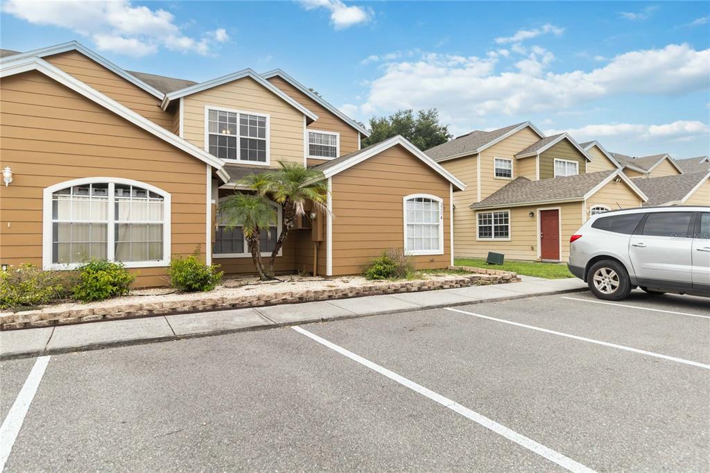 A two-story tan building with a parking lot and a silver minivan in the foreground — 2204 FAN PALM DRIVE, DAVENPORT, FL