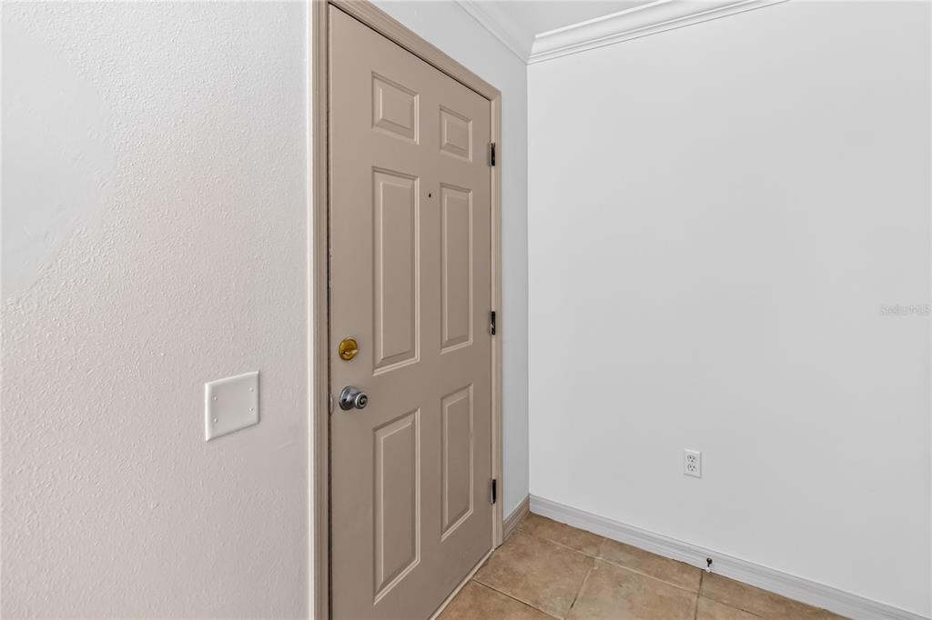 A tan door with a deadbolt and handle is set against a white wall — 2204 FAN PALM DRIVE, DAVENPORT, FL