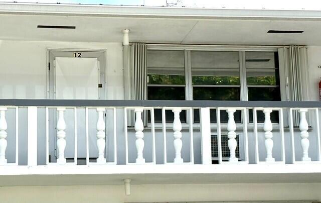 A white exterior balcony features a balustrade railing, a door labeled 12, and large windows — 12 Windsor A # 12, West Palm Beach FL 33417, WEST PALM BEACH, FL