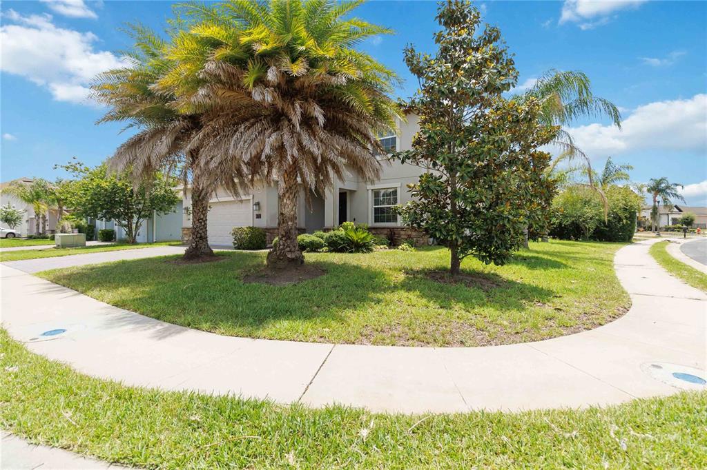 A two-story house with a palm tree and a magnolia tree in the front yard — 472 BRUNSWICK DRIVE, DAVENPORT, FL