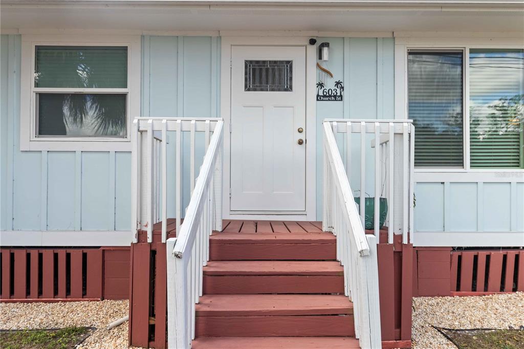 A front exterior view of a house with light blue siding, white trim, and wooden stairs — 603 CHURCH STREET, NOKOMIS, FL