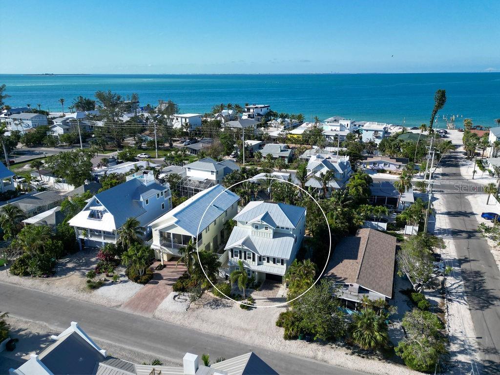 A bright red front door is centered on the light green exterior of a house — 704 GLADIOLUS STREET, ANNA MARIA, FL