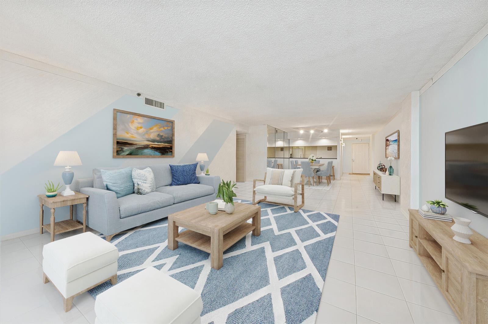 A bright living room features a blue and white rug, light wood furniture, and tiled floors — 3400 S Ocean Boulevard # 4h, Highland Beach FL 33487, HIGHLAND BEACH, FL