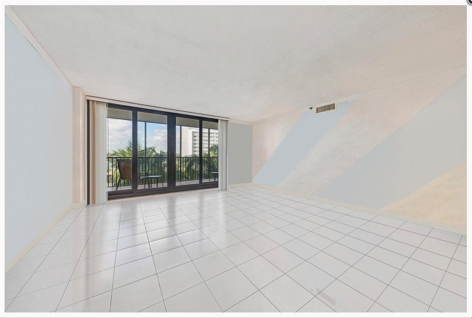 An empty room with white tile flooring, a sliding glass door, and diagonal wall accents — 3400 S Ocean Boulevard # 4h, Highland Beach FL 33487, HIGHLAND BEACH, FL
