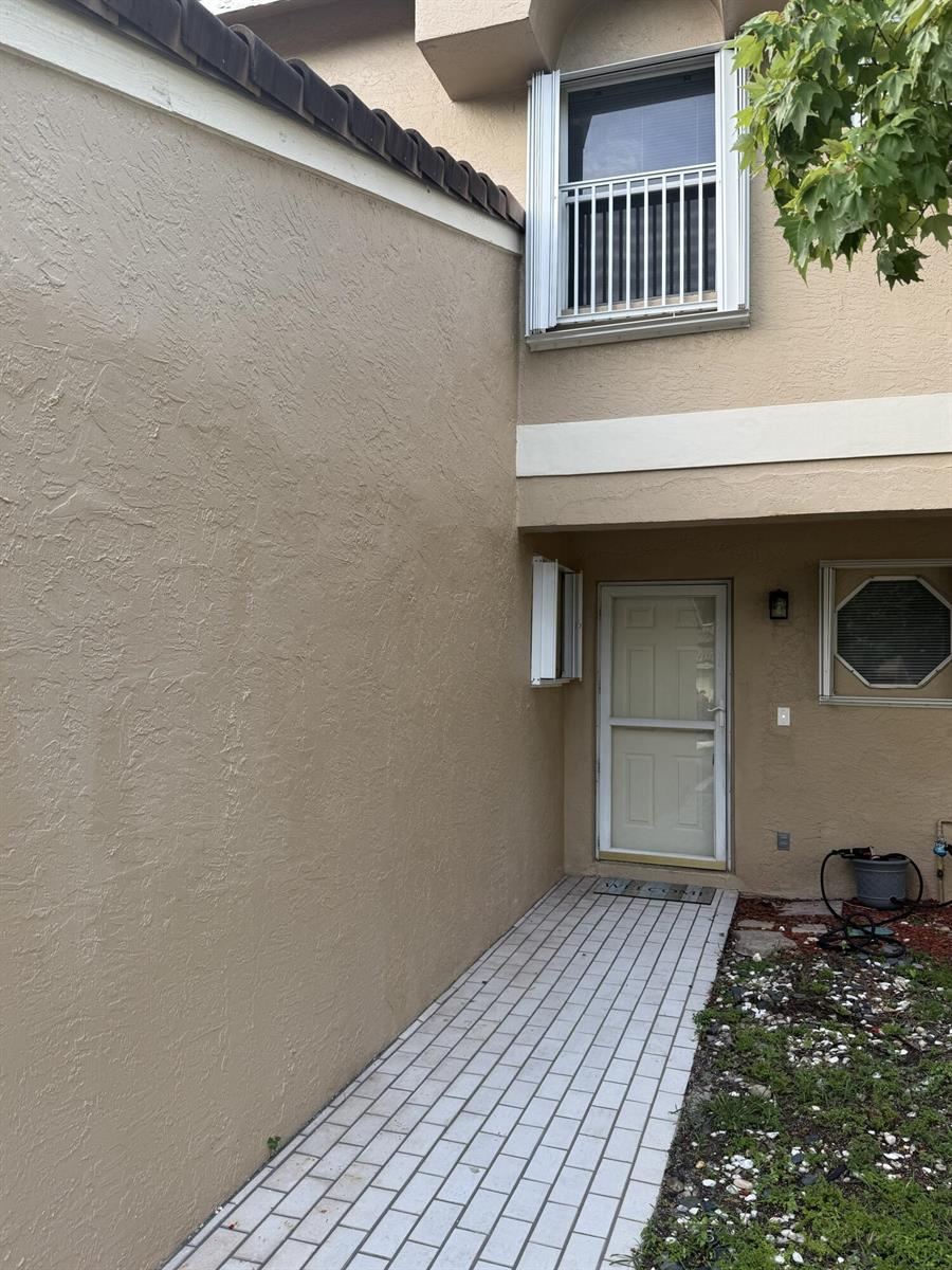 A beige stucco exterior features a tiled walkway leading to a white front door — 3767 NW 91st Lane, Sunrise FL 33351, SUNRISE, FL