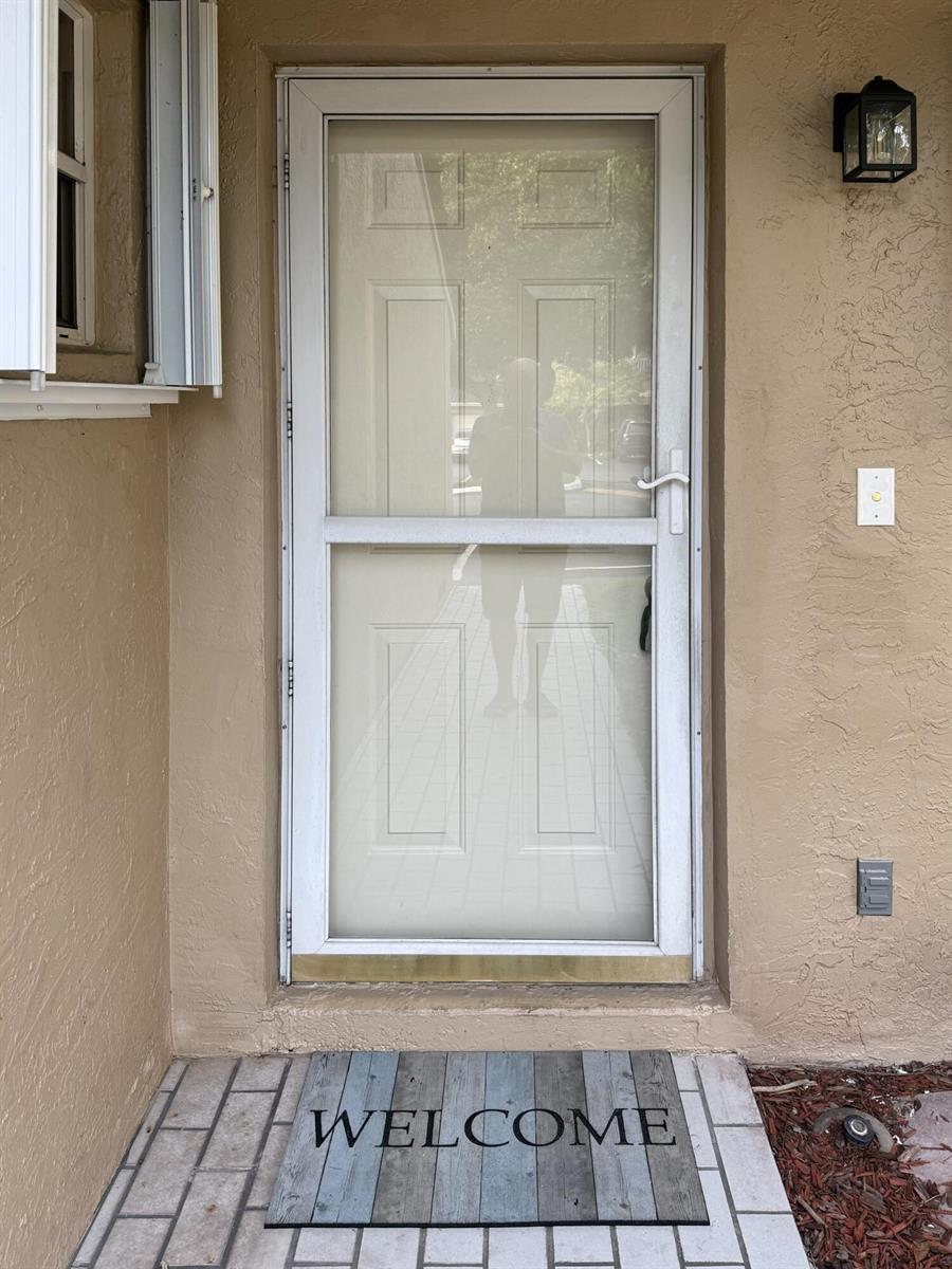 A white storm door with a welcome mat sits at the entrance of a home — 3767 NW 91st Lane, Sunrise FL 33351, SUNRISE, FL