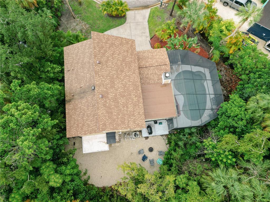 An aerial view shows a house with a shingled roof, screened pool, and backyard patio — 4003 BAYSIDE COURT, BRADENTON, FL