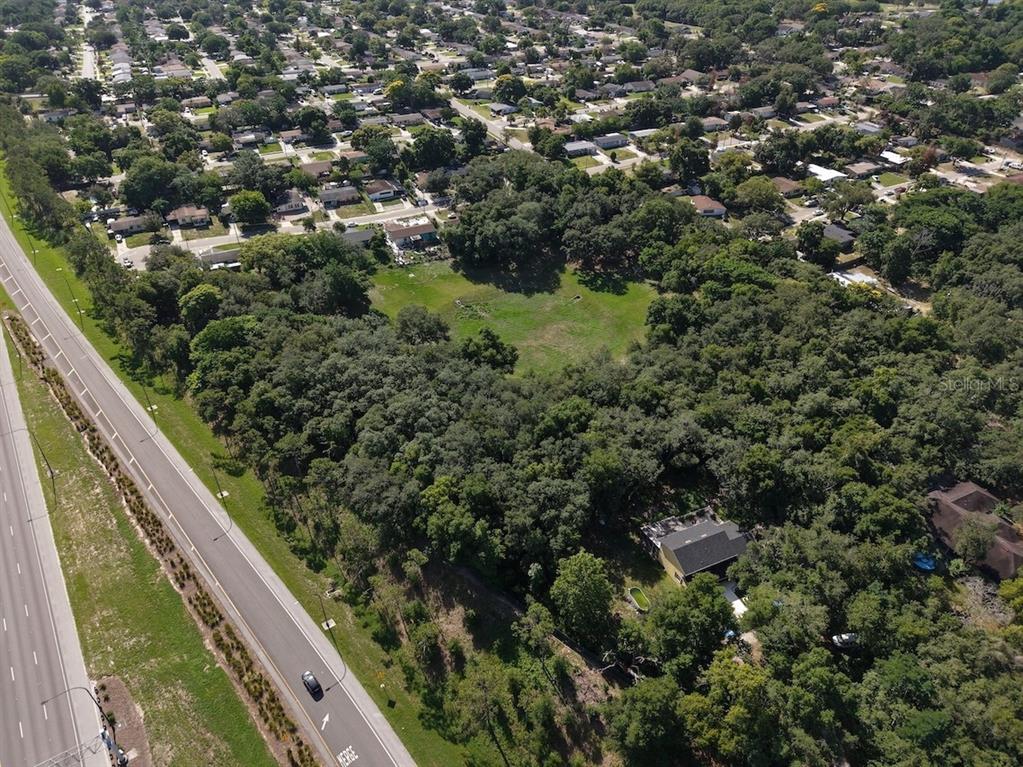 An aerial view shows a large, wooded lot adjacent to a multi-lane highway — 481 N LANCELOT AVENUE, ORLANDO, FL