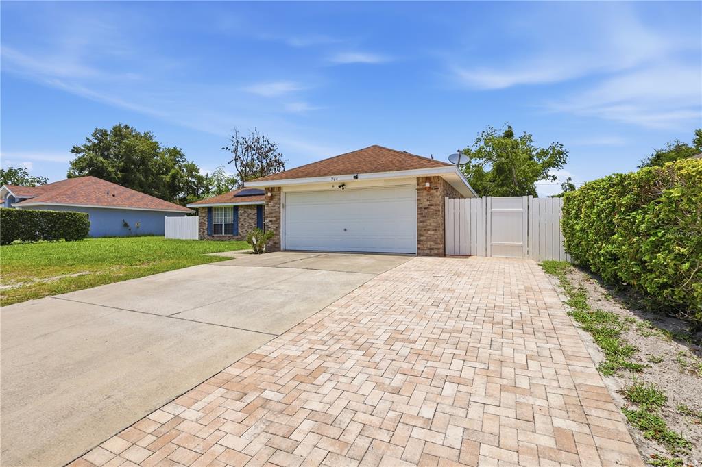 A single-story house with a brick facade, a two-car garage, and a paved driveway — 964 FORT SMITH BOULEVARD, DELTONA, FL