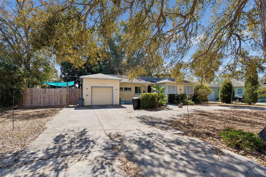 A single-story house with a yellow exterior, a one-car garage, and a concrete driveway — 2120 CORONADA WAY S, ST PETERSBURG, FL