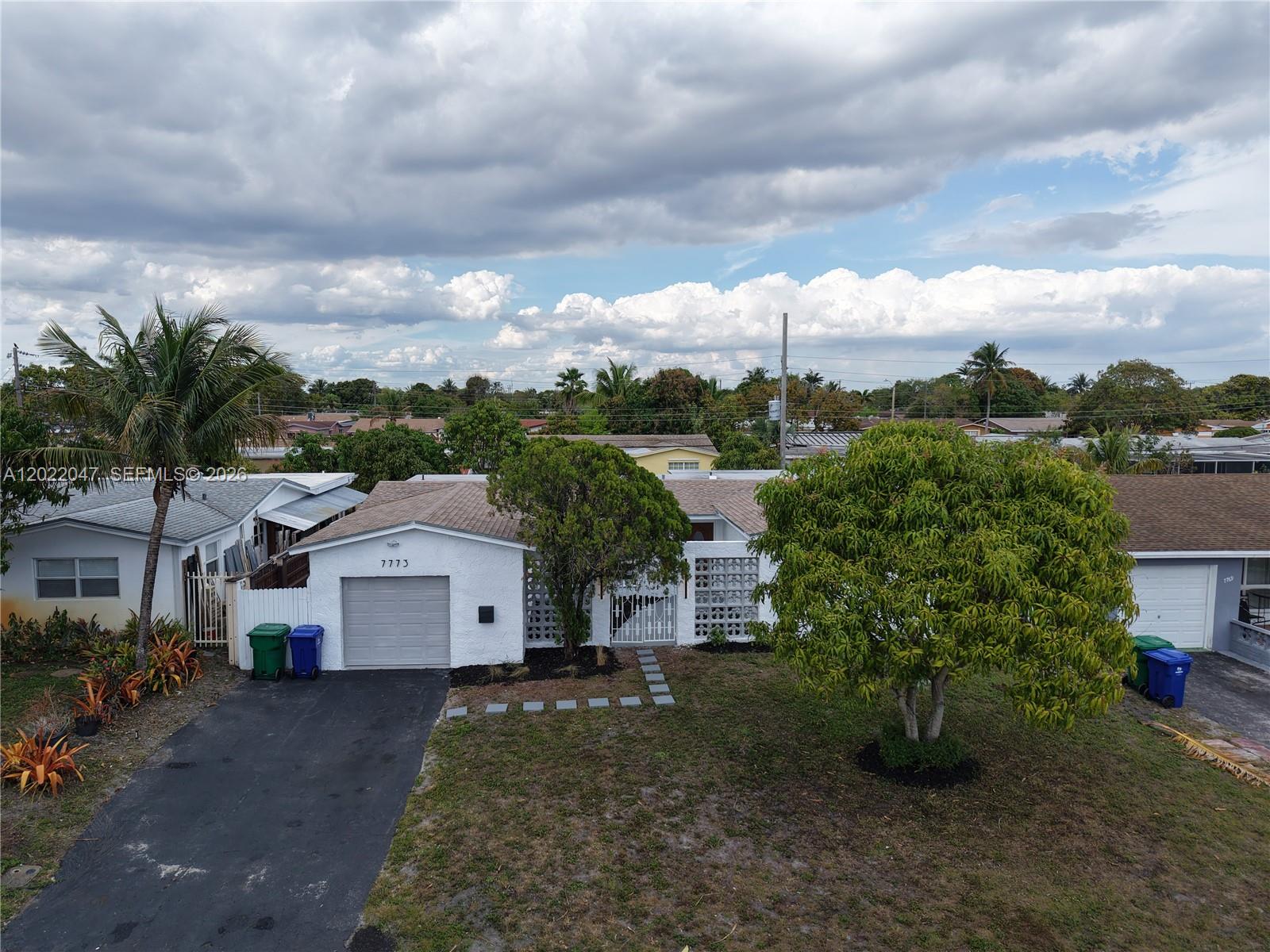 An aerial view shows a white single-story house with a garage and a large tree — 7773 Coral Blvd, Miramar FL 33023, MIRAMAR, FL