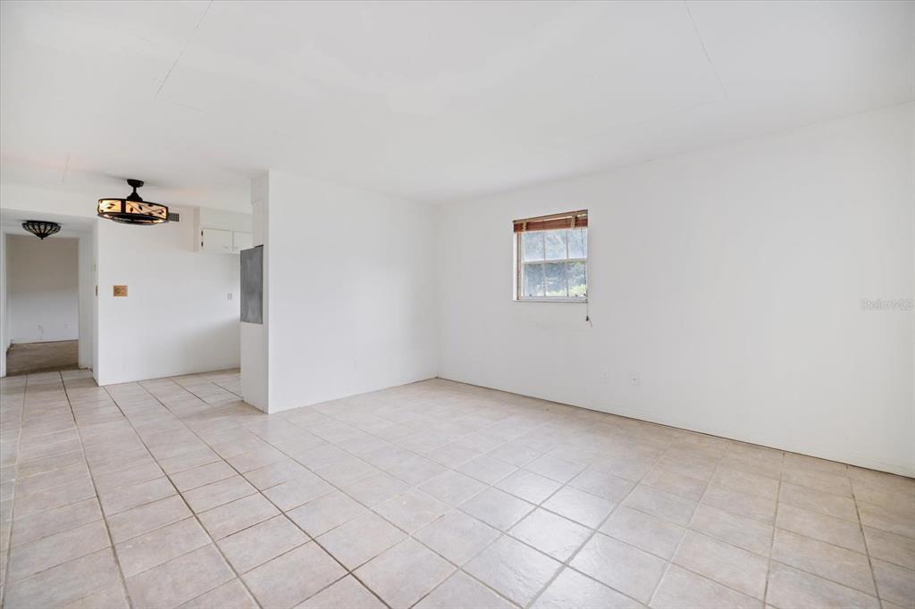 A bright, empty room with white walls, light-colored floor tiles, and a single window — 450 32ND AVENUE N UNIT 106W, ST PETERSBURG, FL