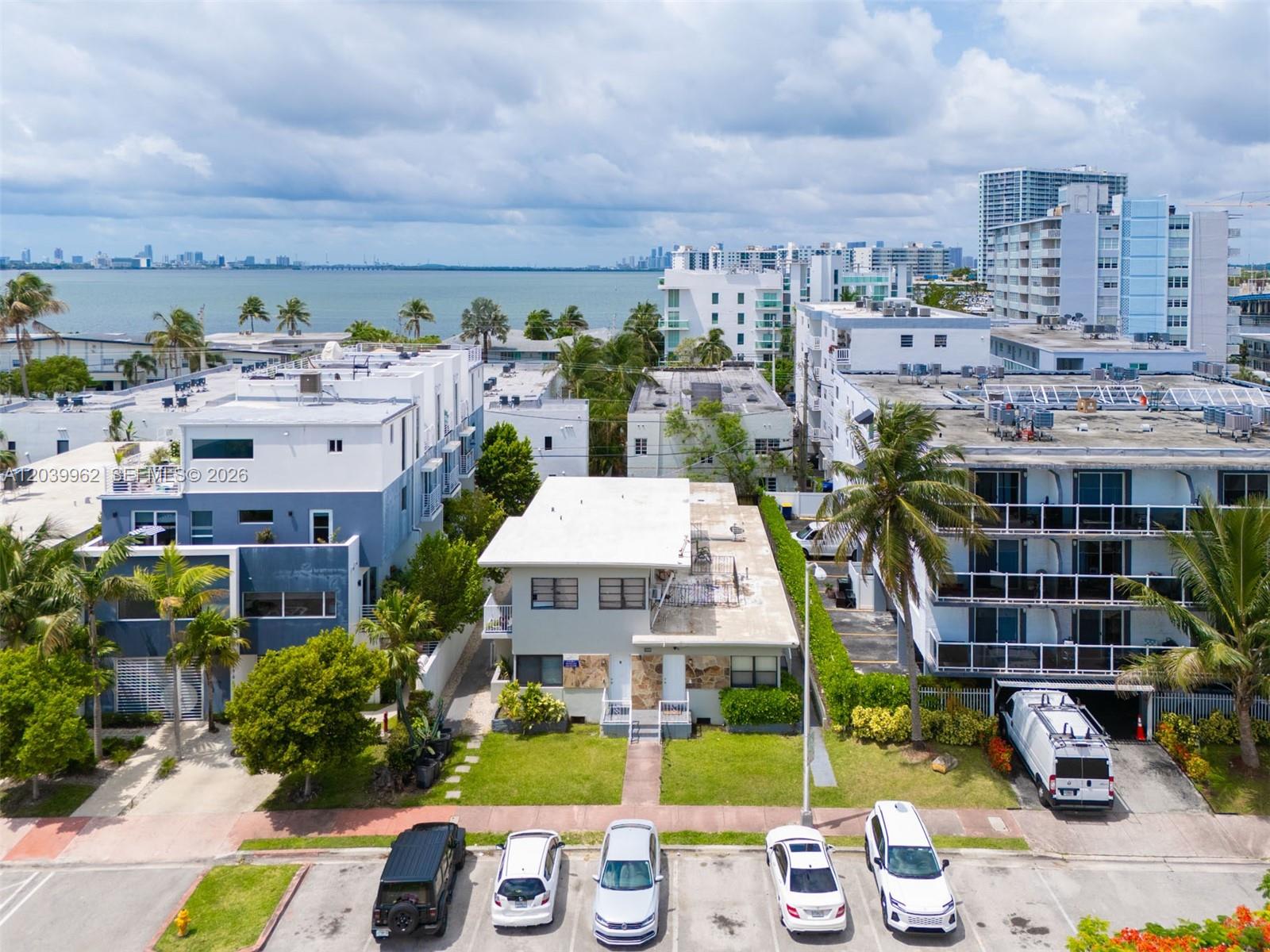 An aerial view shows a two-story residential building surrounded by apartment complexes and palm trees — 1980 Biarritz Dr, Miami Beach FL 33141, MIAMI BEACH, FL