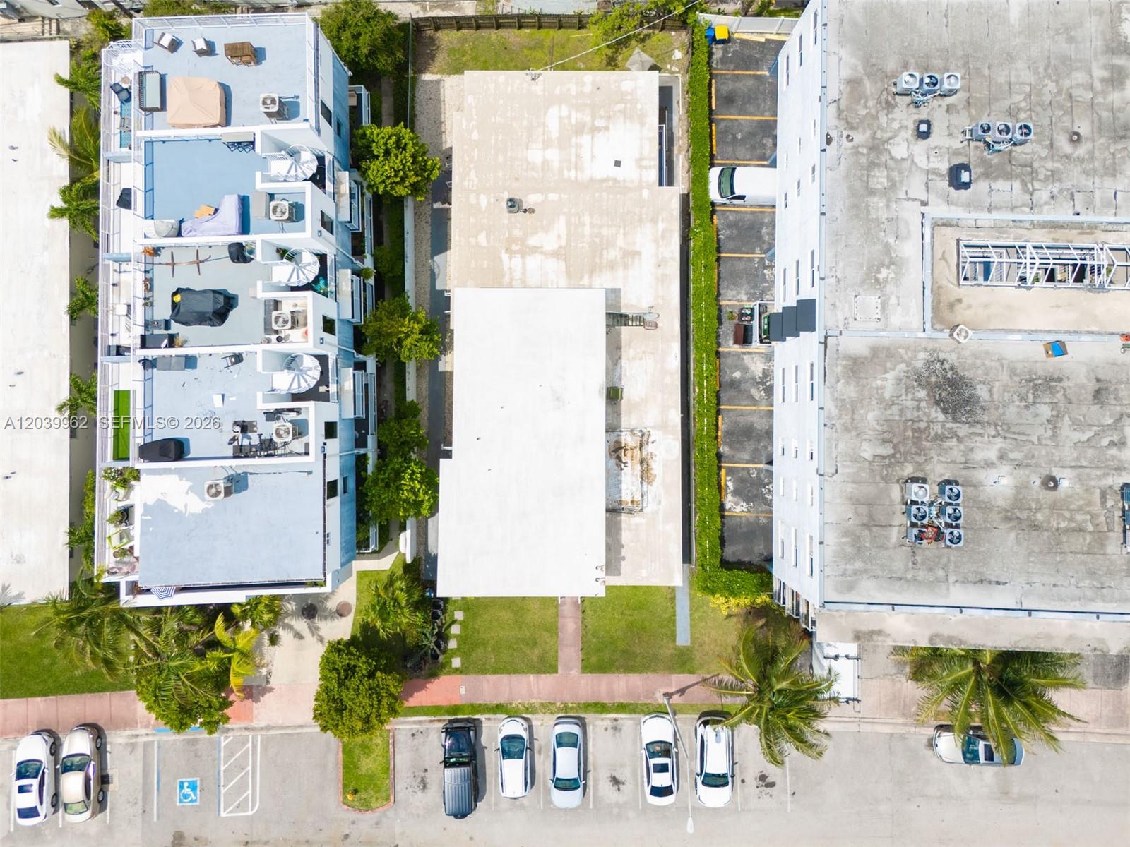 An aerial view shows three adjacent buildings with parking lots and surrounding landscaping — 1980 Biarritz Dr, Miami Beach FL 33141, MIAMI BEACH, FL