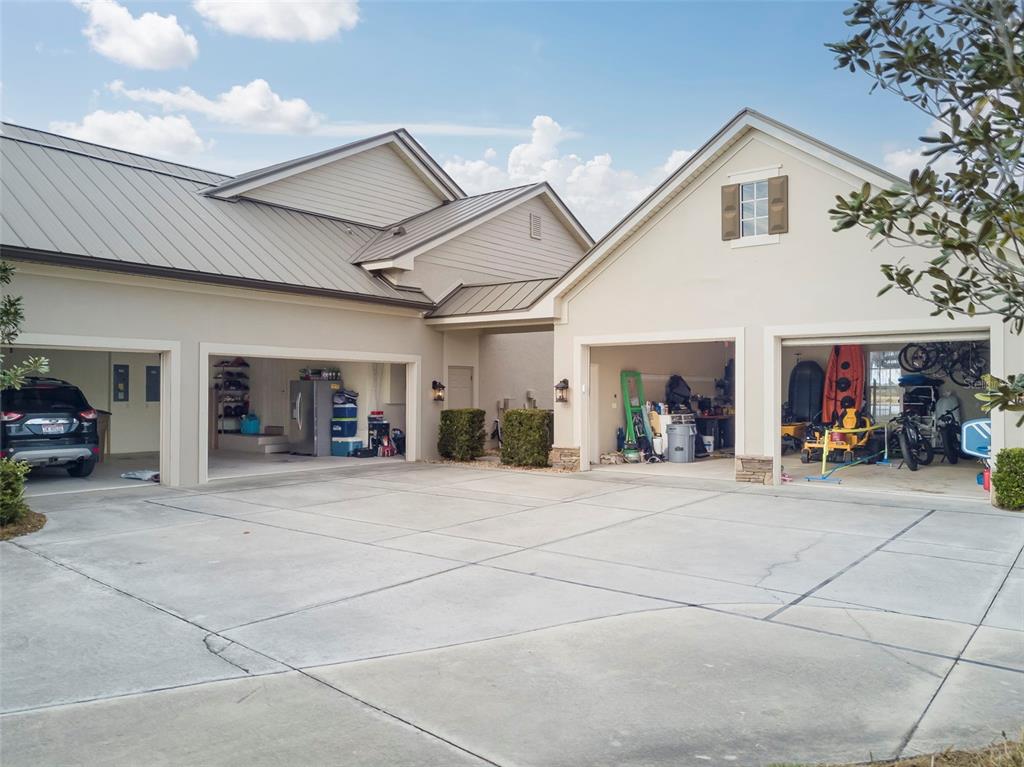 A four-car garage with open bays and a concrete driveway in front of a house — 2131 SILK BAY BOULEVARD, ALVA, FL