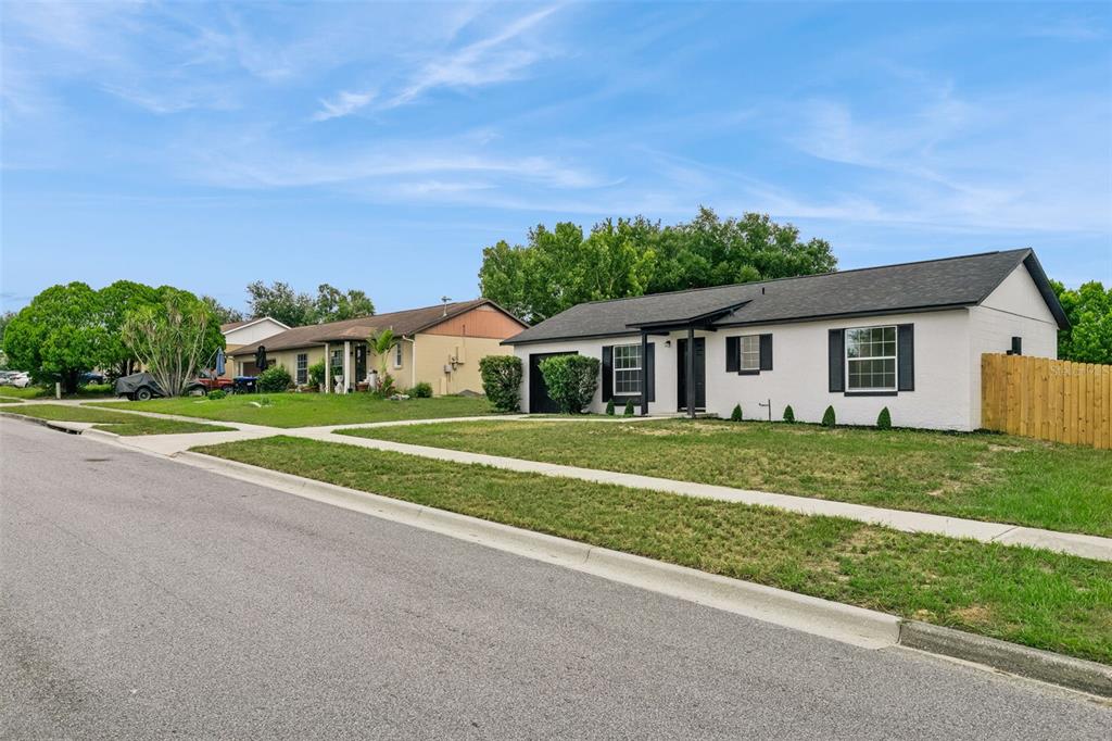 A white single-story house with a dark roof and black shutters sits on a street — 3117 KNIGHTSBRIDGE ROAD, ORLANDO, FL