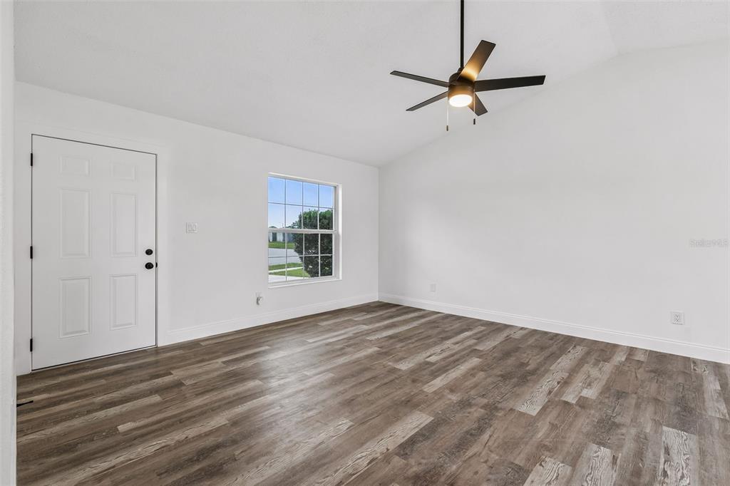 An empty room with white walls, wood-look flooring, a ceiling fan, and a single window — 3117 KNIGHTSBRIDGE ROAD, ORLANDO, FL