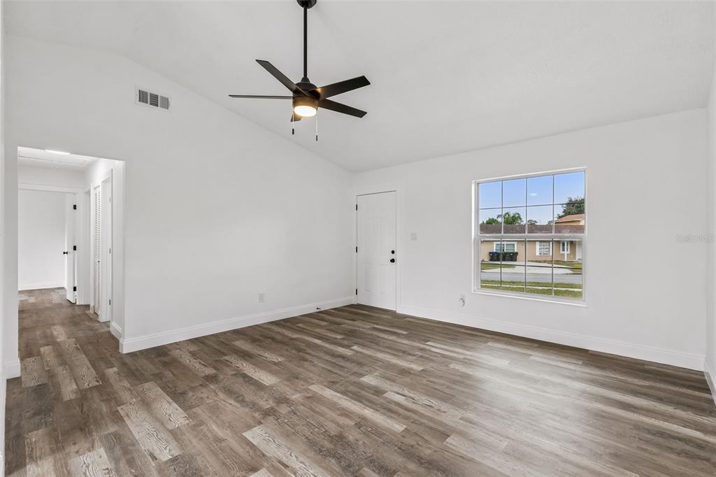 An empty room with white walls, wood-look flooring, a ceiling fan, and a window — 3117 KNIGHTSBRIDGE ROAD, ORLANDO, FL