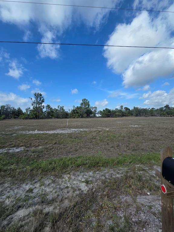 A vacant, grassy lot under a blue sky with scattered clouds — 3813 NW 46TH LANE, CAPE CORAL, FL