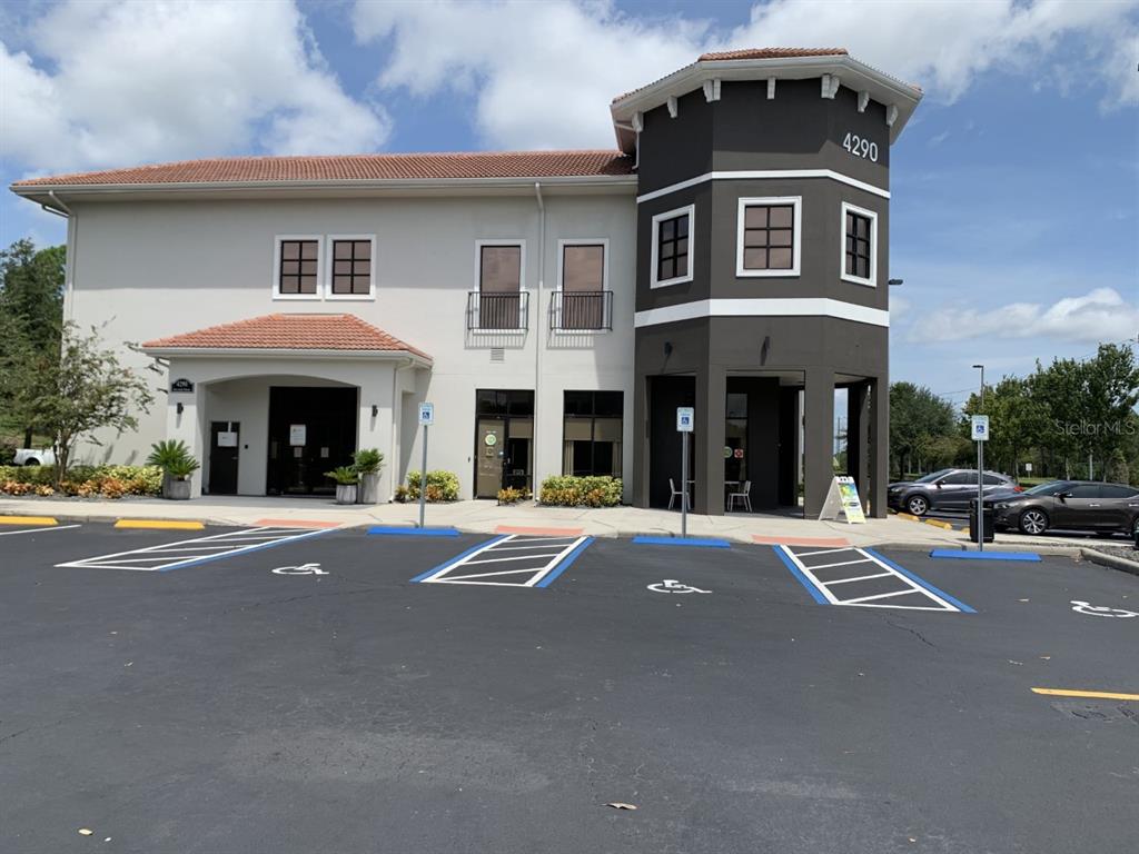 A two-story commercial building features a dark brown corner tower and accessible parking spaces — 4290 S HIGHWAY 27 UNIT 206, CLERMONT, FL