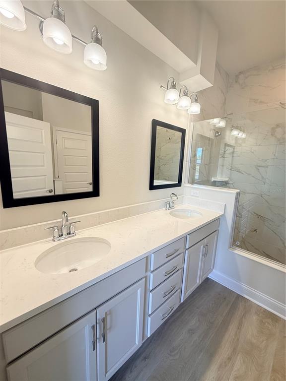 A bathroom features a double vanity with white cabinets, quartz countertops, and a glass-enclosed shower — 29 SPRING STREET, PALM COAST, FL