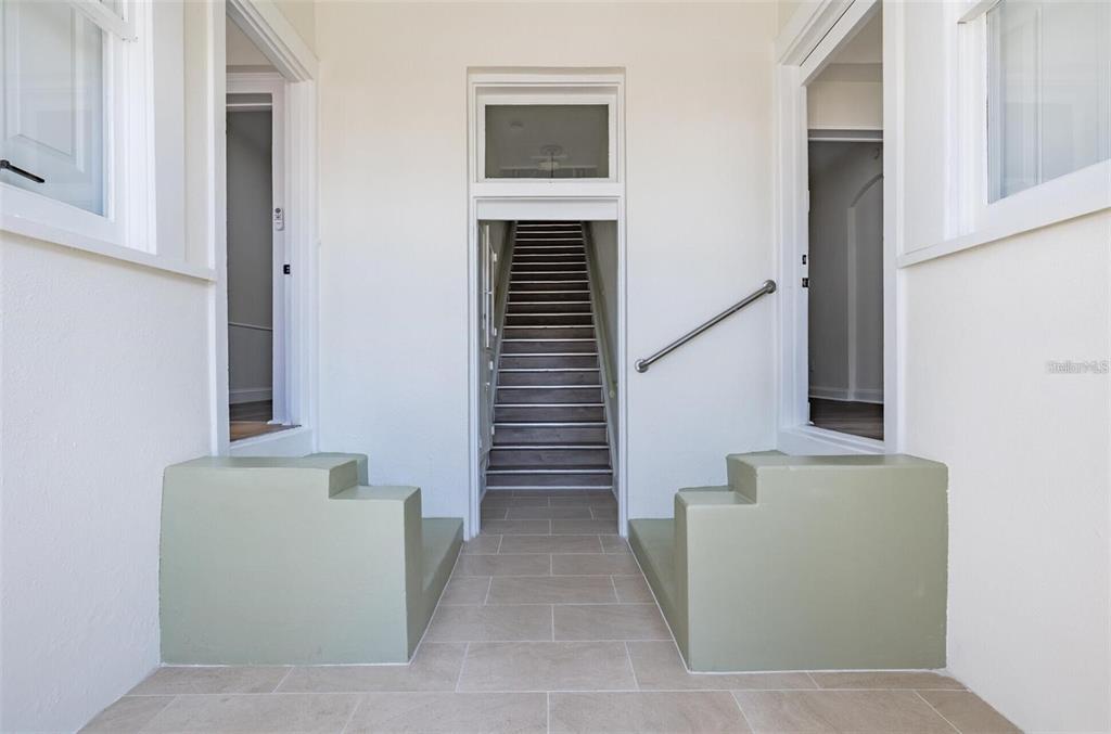 A tiled entryway features two green stepped platforms flanking a central staircase leading upward — 218 N PINELLAS AVENUE, TARPON SPRINGS, FL