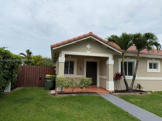 A single-story house with a tan exterior, a brown tiled roof, and a small front porch — 706 SE 14th Ave, Homestead FL 33033, HOMESTEAD, FL