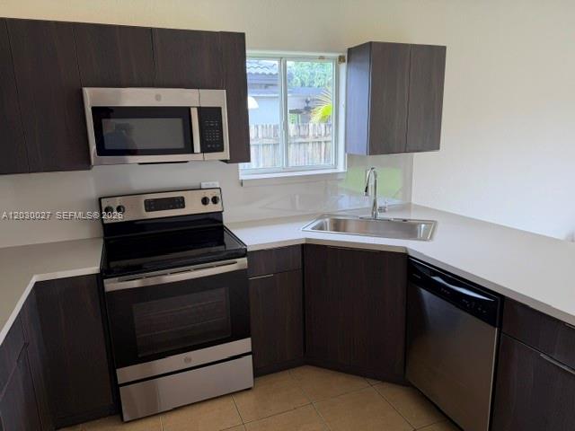 A kitchen features dark wood cabinets, stainless steel appliances, and white countertops — 706 SE 14th Ave, Homestead FL 33033, HOMESTEAD, FL