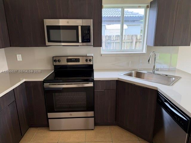 A kitchen features dark wood cabinets, stainless steel appliances, and white countertops — 706 SE 14th Ave, Homestead FL 33033, HOMESTEAD, FL