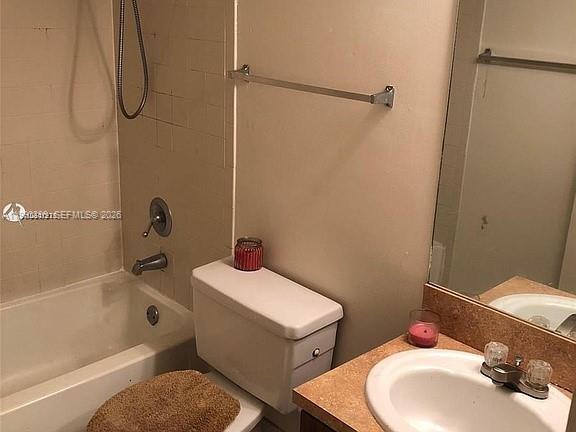 A bathroom features a white toilet, a bathtub with a showerhead, and a vanity sink — 7235 NW 179th St # 103, Hialeah FL 33015, HIALEAH, FL