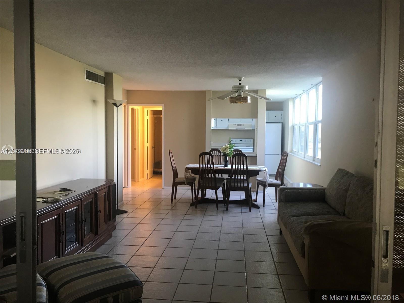 A living and dining area with tile floors, a ceiling fan, and a kitchen pass-through — 9470 Live Oak Pl # 306, Davie FL 33324, DAVIE, FL